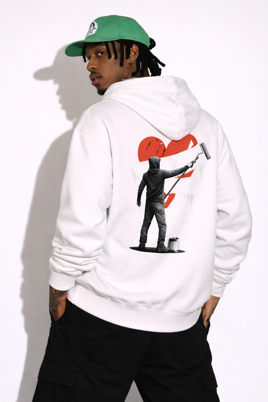 Noiré white oversized hoodie back view with large red heart and artistic streetwear character print, worn by male model, statement graphic hoodie.