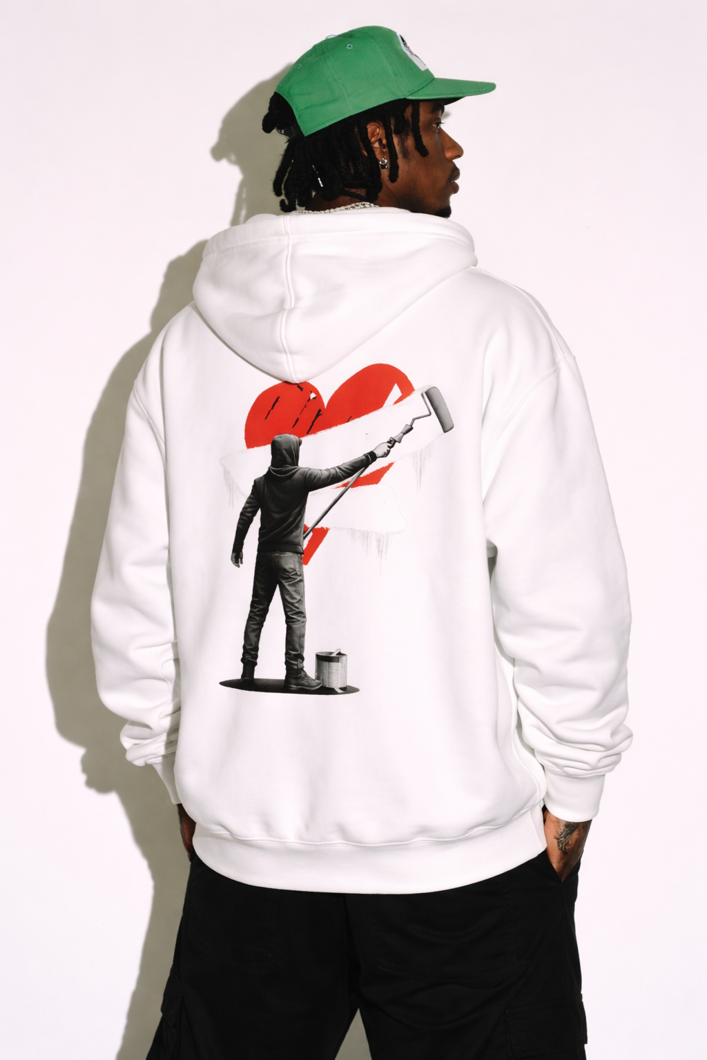 Noiré white oversized hoodie back view with large red heart and artistic streetwear character print, worn by male model, statement graphic hoodie.