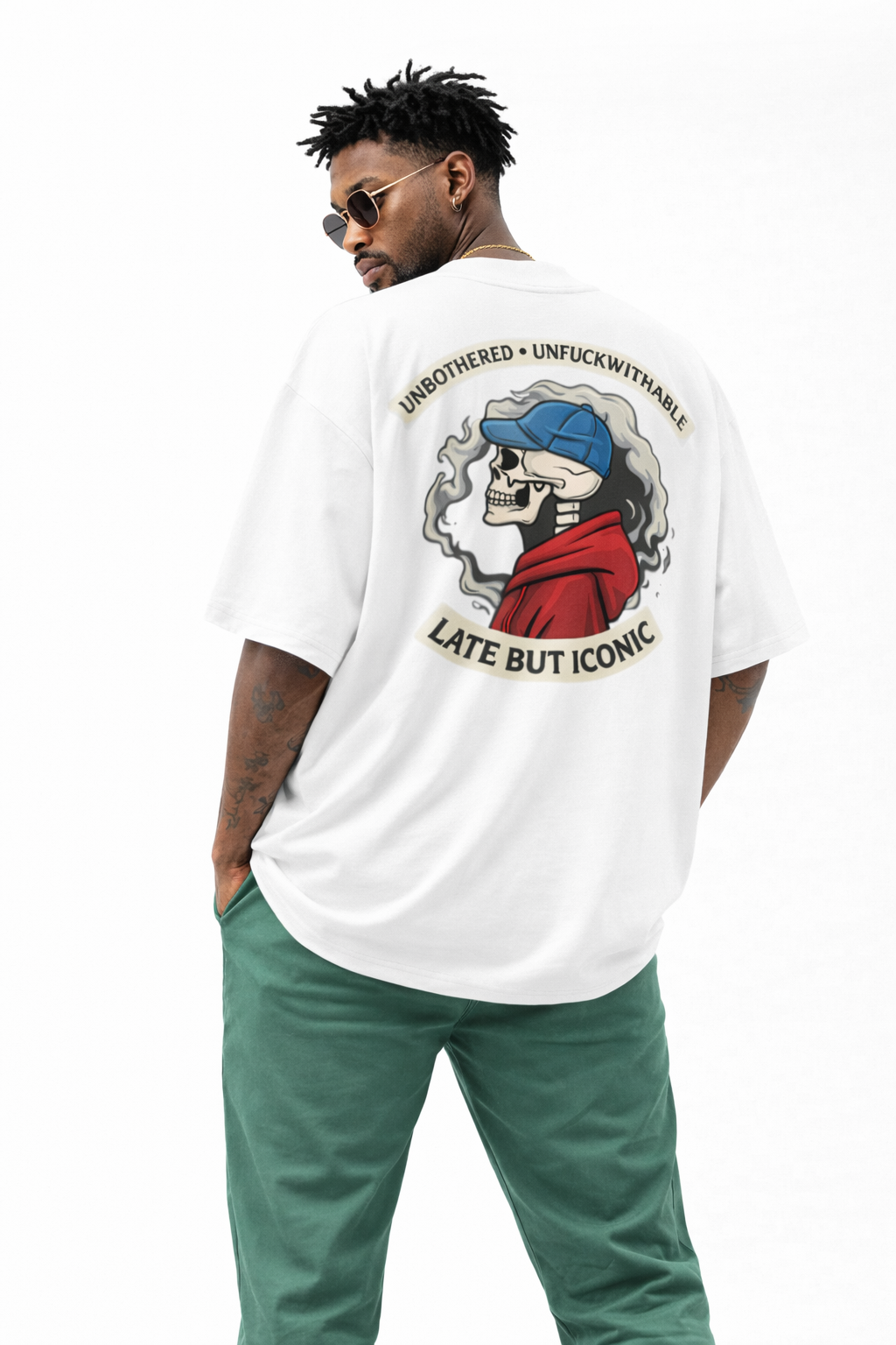 White oversized Noiré T-shirt back view with “Unbothered · Unfuckwithable – Late But Iconic” skull artwork, statement streetwear piece.