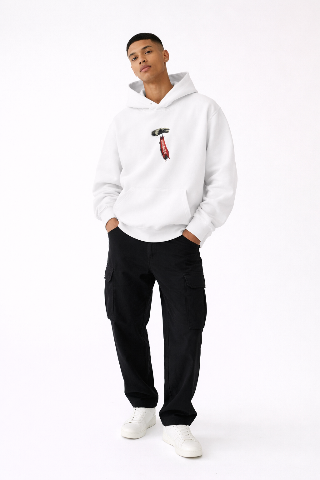 White oversized hoodie for men with small front graphic detail, streetwear style outfit with black cargo pants, studio fashion photography