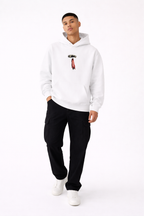 White streetwear hoodie front view on male model with minimalist chest print, black cargo pants and white sneakers, clean white background