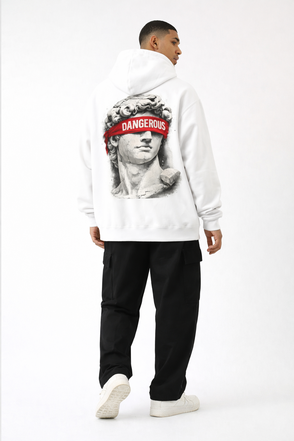 White oversized hoodie back print with classical statue and bold red “DANGEROUS” lettering, male model full body studio image