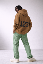 Men’s camel brown oversized hoodie with large “123” back number print, urban streetwear hoodie product photo for online store.