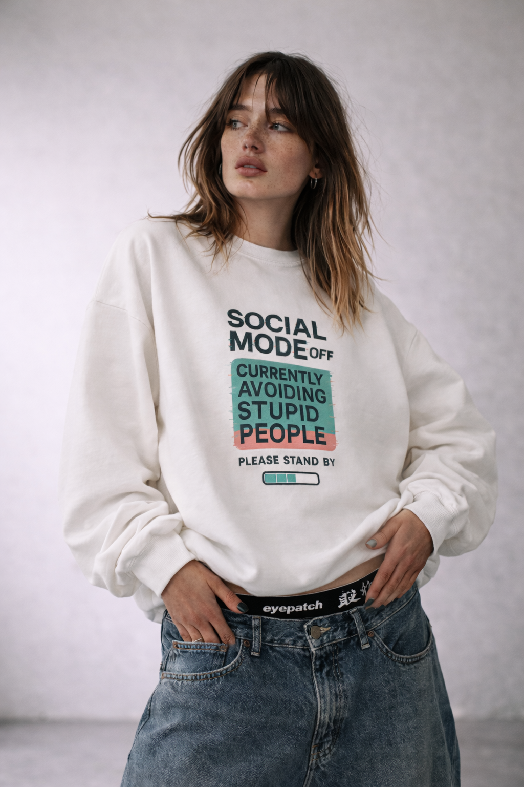 White women’s oversized crewneck sweatshirt featuring “Social Mode Off” statement graphic, modern women’s streetwear fashion product image.