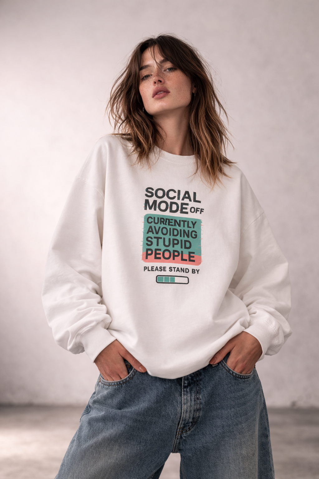 Women’s white statement sweatshirt with bold “Social Mode Off – Currently Avoiding Stupid People” front print, oversized streetwear sweater styled with denim jeans.