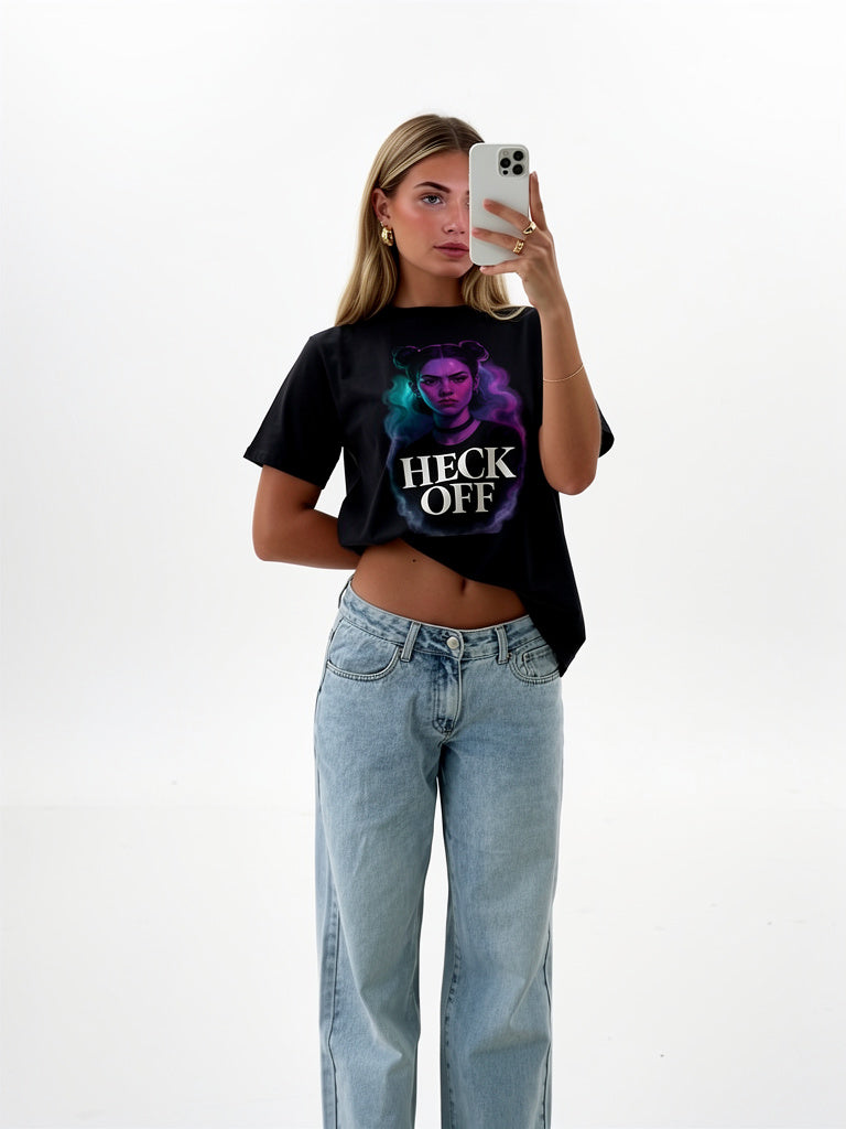 Model wearing black unisex graphic t-shirt with “Heck Off” portrait design, lifestyle studio photo