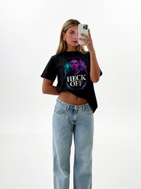 Model wearing black unisex graphic t-shirt with “Heck Off” portrait design, lifestyle studio photo