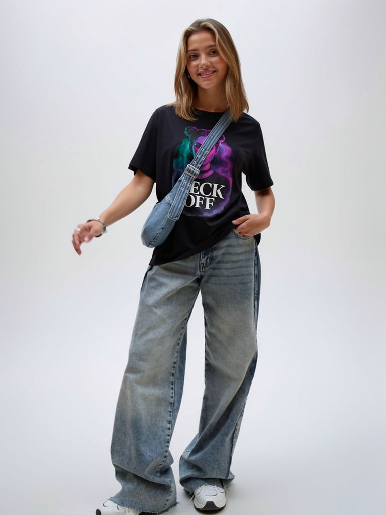 Model wearing black unisex graphic t-shirt with bold portrait artwork, casual lifestyle look