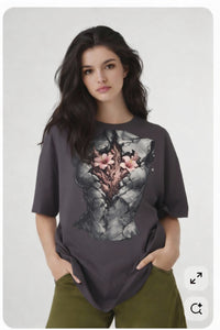 Model wearing dark grey t-shirt with anatomical heart illustration, relaxed creative streetwear outfit by Noiré.