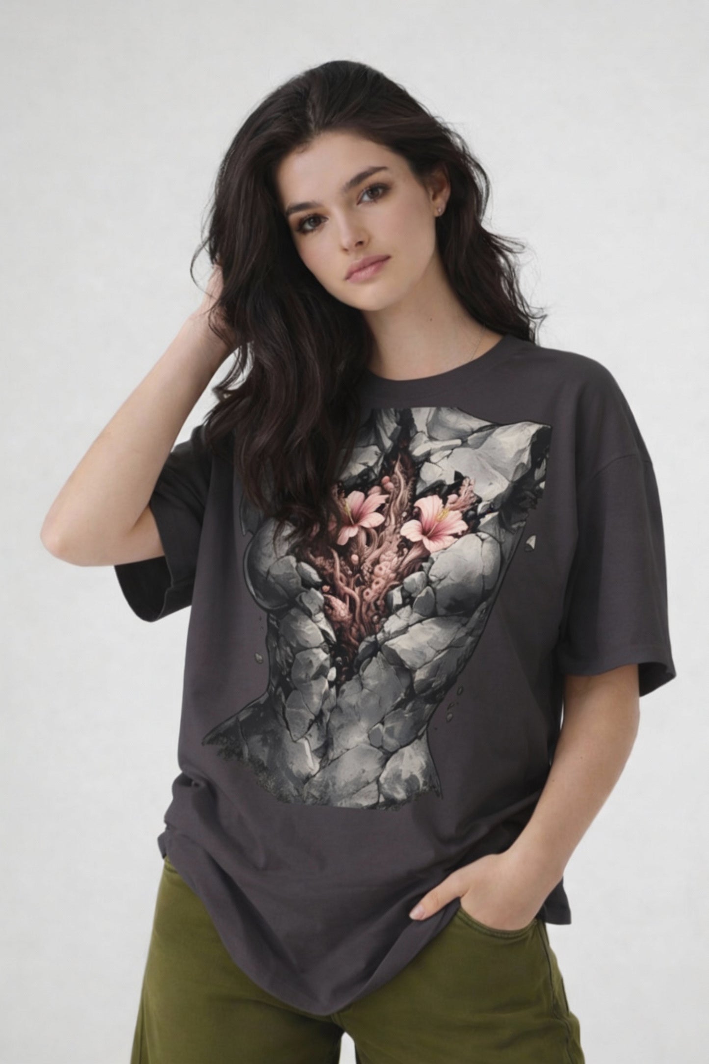Model wearing dark grey t-shirt with anatomical heart illustration, relaxed creative streetwear outfit by Noiré.