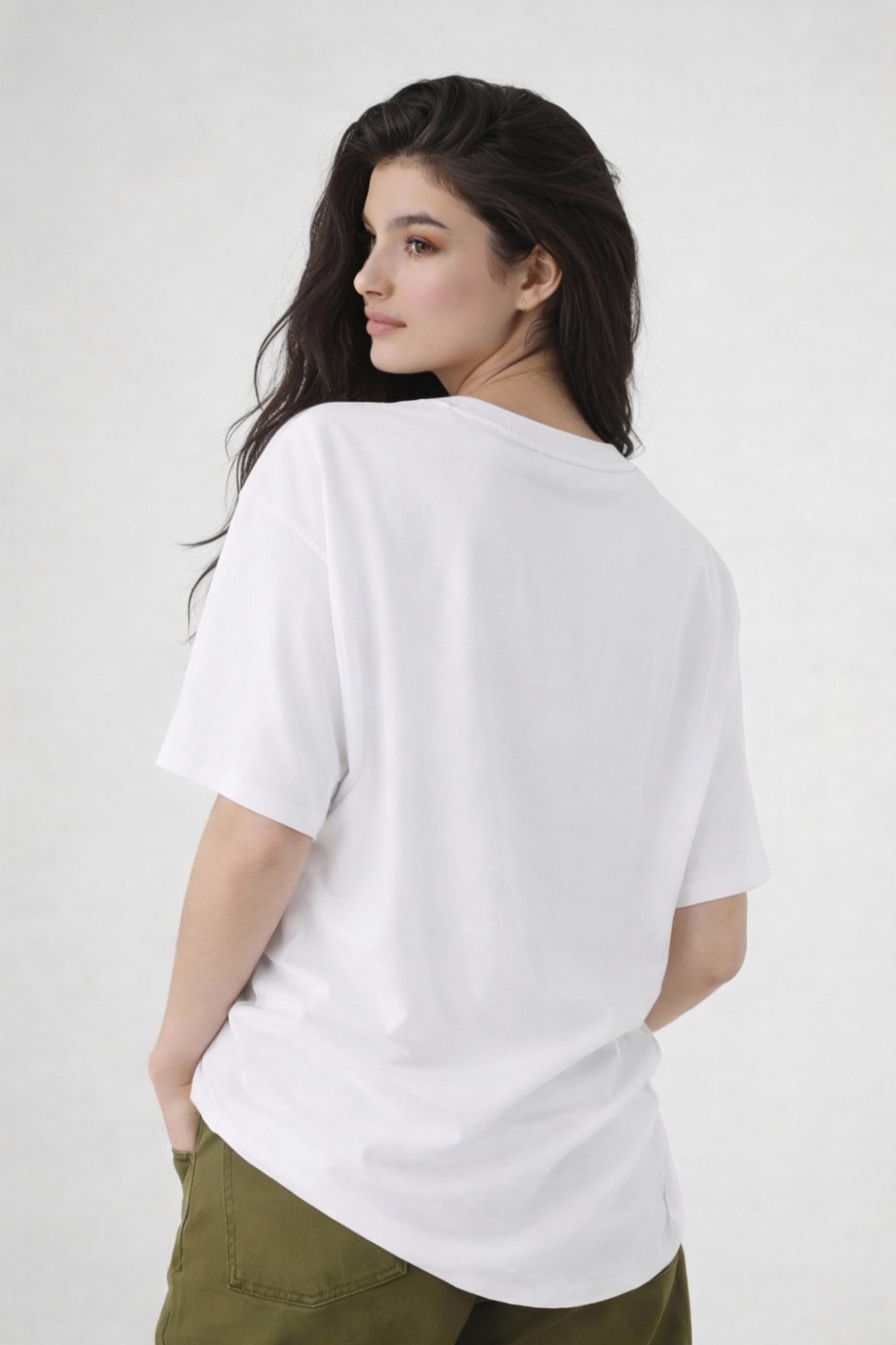 Model seen from back wearing white oversized t-shirt , casual streetwear outfit by Noiré.