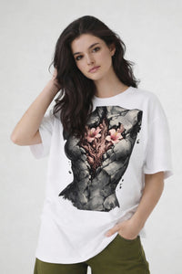 Model wearing white t-shirt with anatomical heart illustration, oversized urban streetwear look by Noiré.