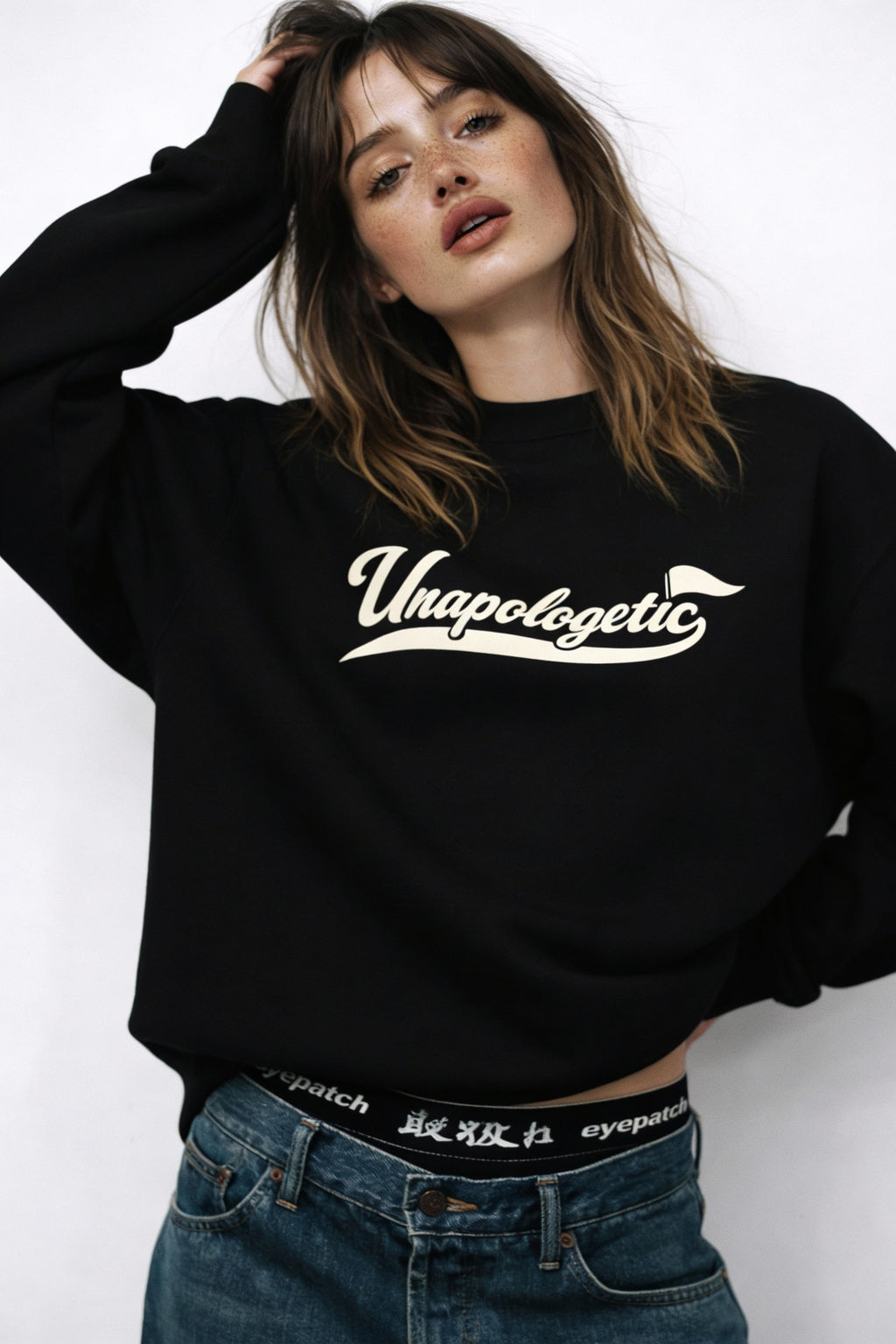 Noiré Unapologetic black crewneck sweatshirt, front view on female model, oversized streetwear fit
