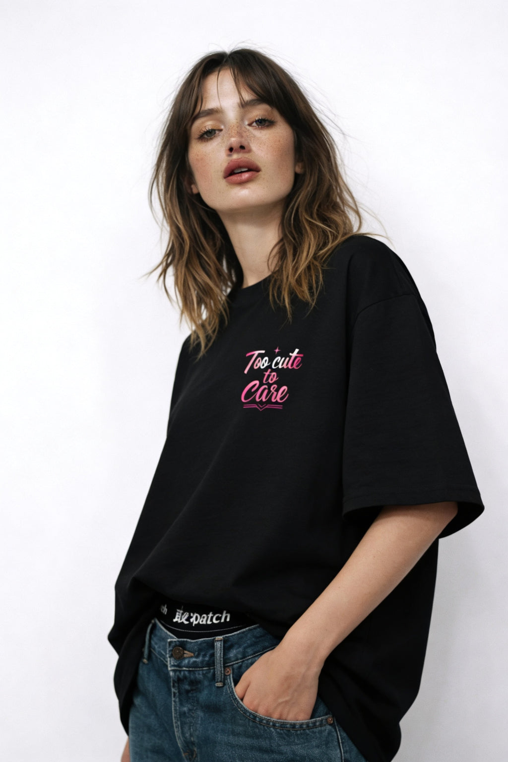 Female model posing in relaxed urban outfit wearing black graphic tee with pastel editorial artwork