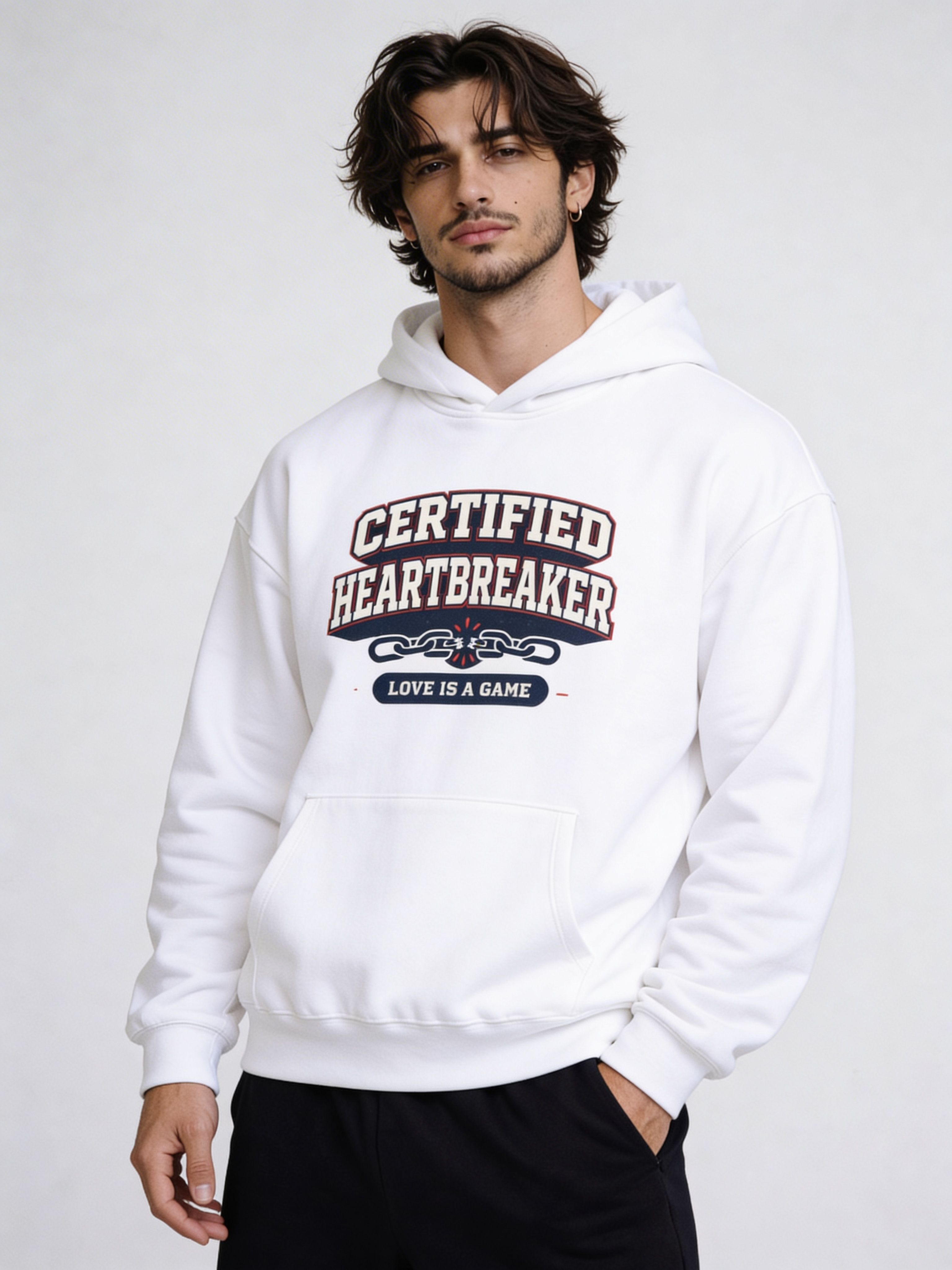 Noiré white oversized hoodie front view with “Certified Heartbreaker – Love Is a Game” varsity graphic print, worn by male model, streetwear Valentine drop.