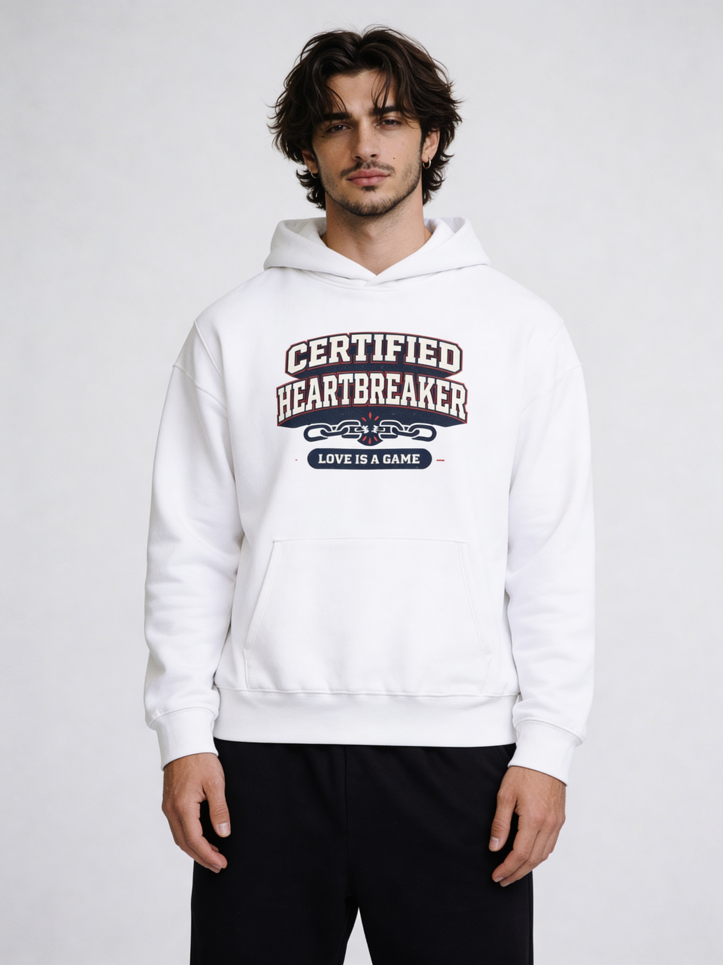 Noiré white oversized hoodie front view with “Certified Heartbreaker – Love Is a Game” varsity graphic print, worn by male model, streetwear Valentine drop.