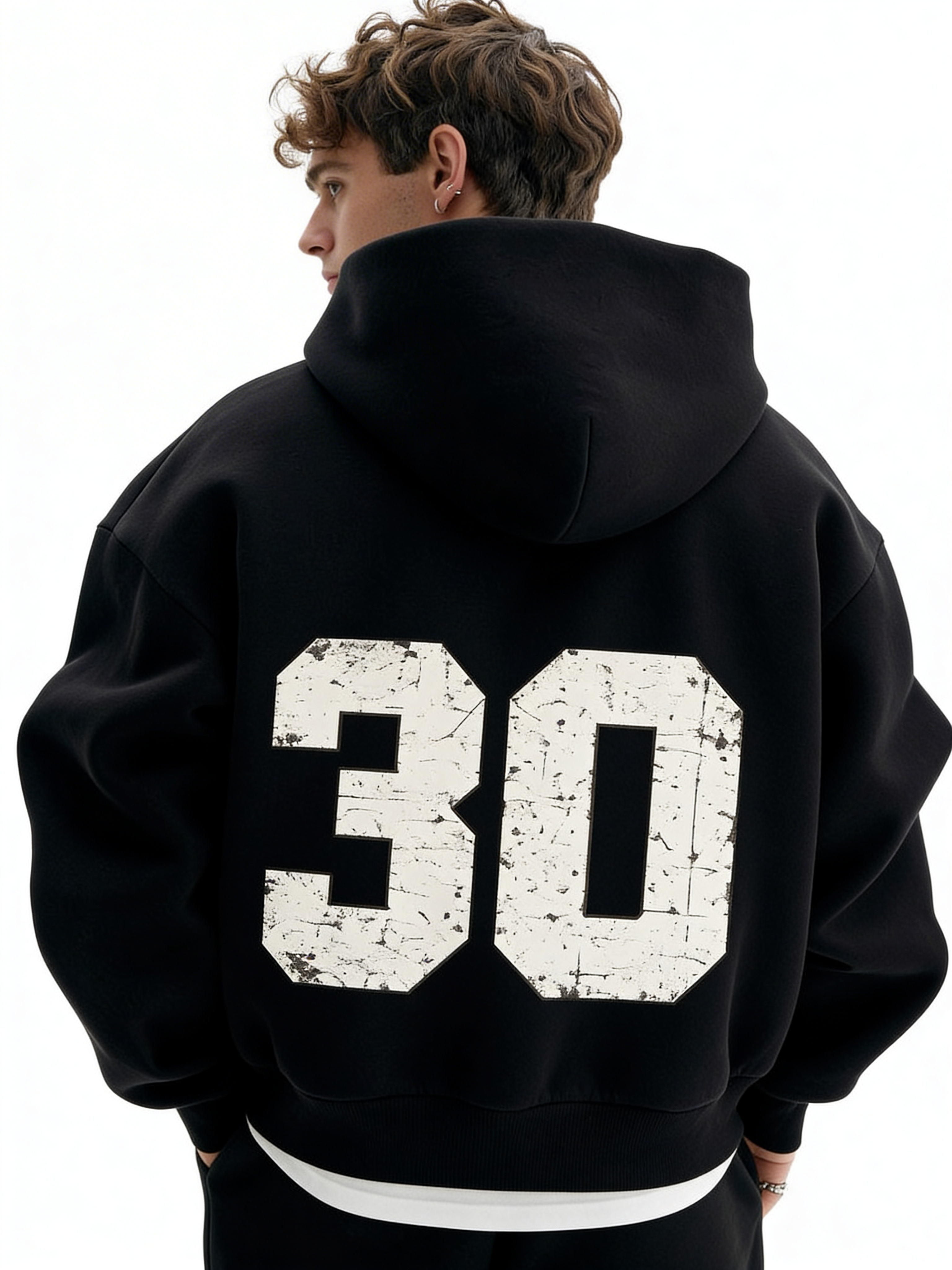Noiré black oversized streetwear hoodie back view with large distressed “30” varsity number print, worn by male model, urban graphic hoodie.
