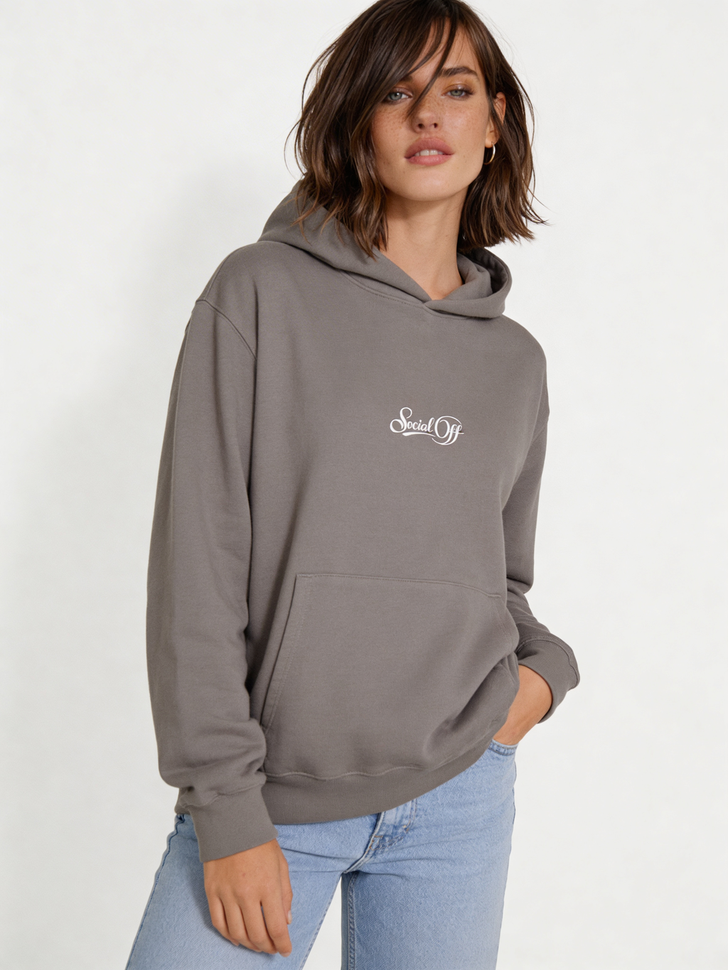 Noiré grey oversized streetwear hoodie front view featuring small “Social Off” logo print, worn by female model, minimalist graphic hoodie.