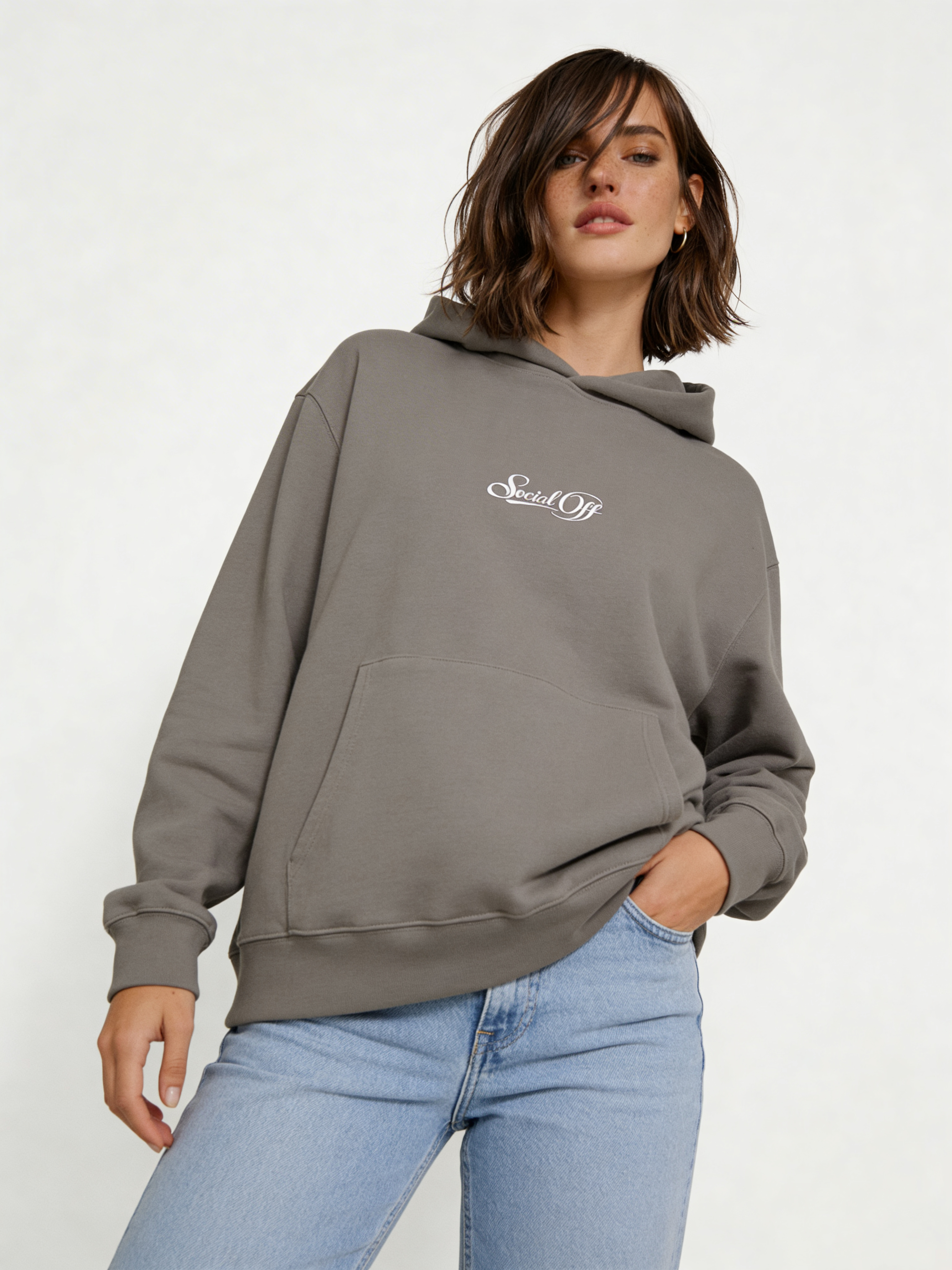 Noiré grey oversized streetwear hoodie front view featuring small “Social Off” logo print, worn by female model, minimalist graphic hoodie.