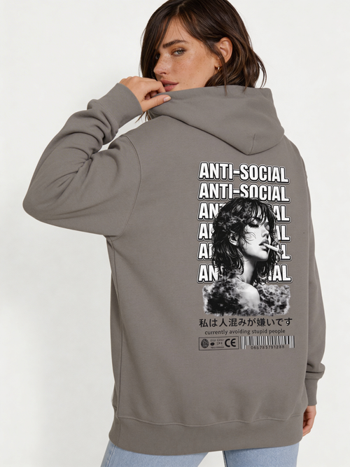 Noiré grey oversized hoodie back view with bold “Anti-Social” repeated typography and black and white portrait graphic, worn by female model, statement streetwear hoodie.
