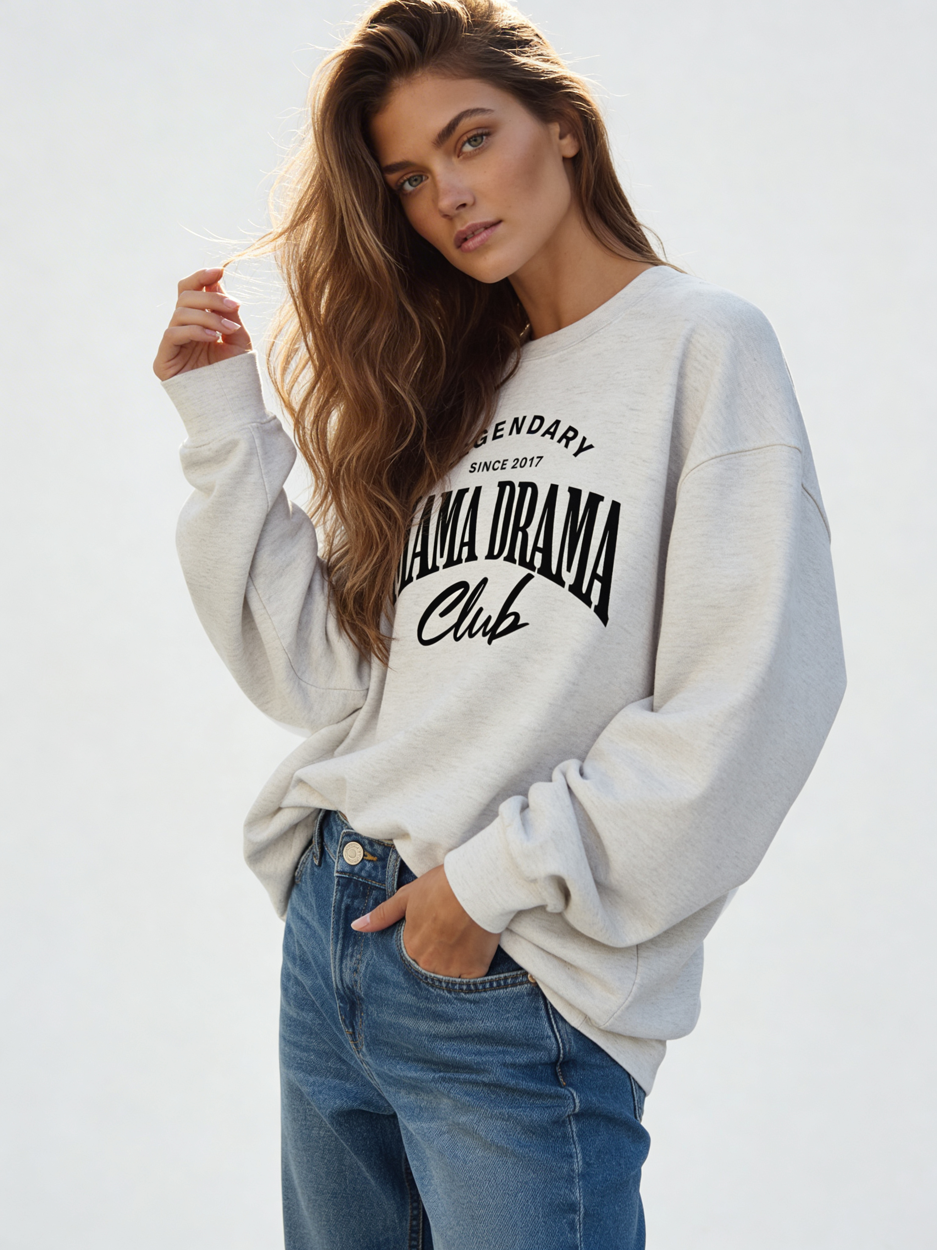 Noiré Legendary Mama Drama Club oversized crewneck sweatshirt for women in oatmeal, front view, bold black typography graphic, streetwear aesthetic.