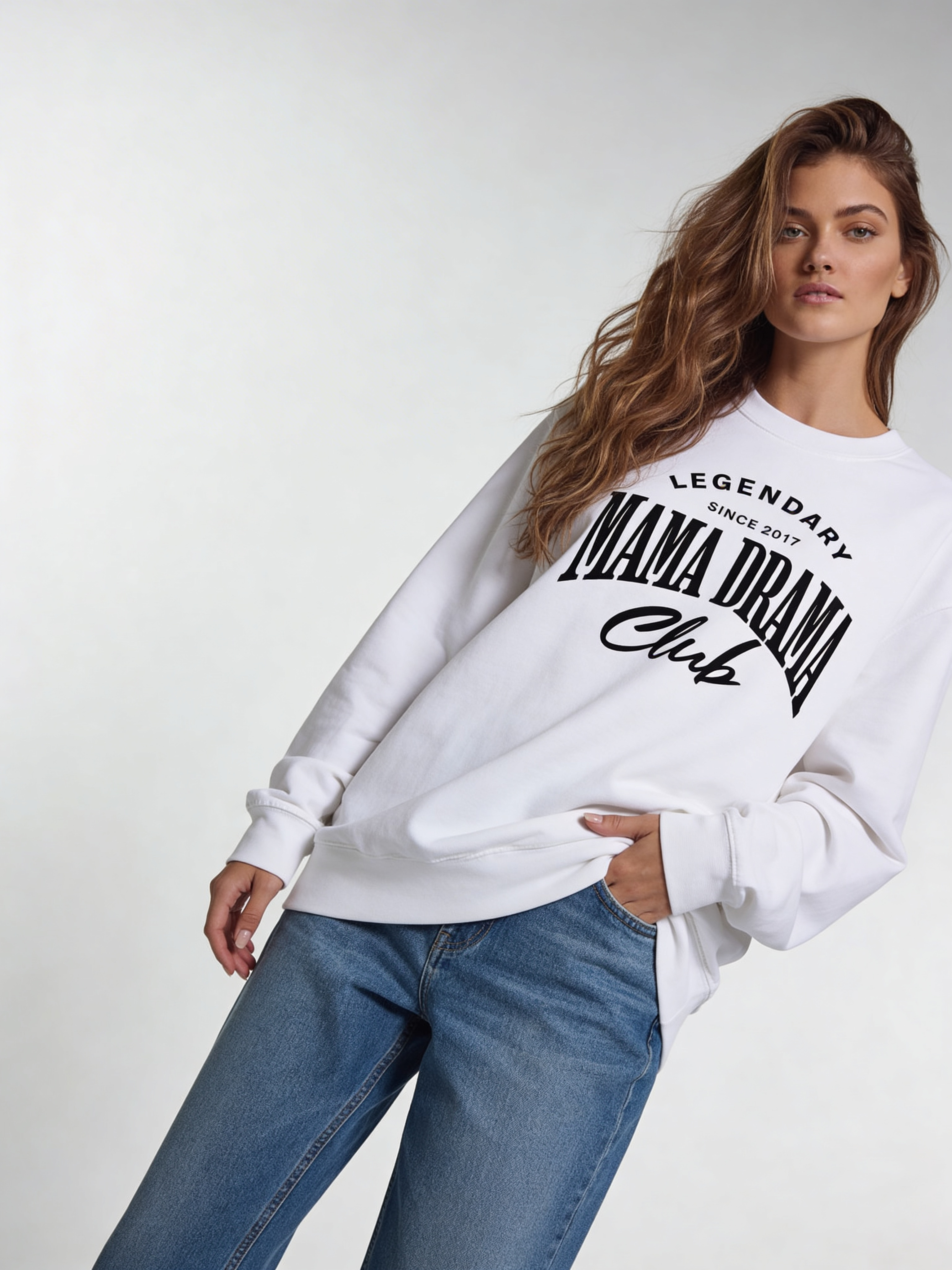 Noiré Legendary Mama Drama Club oversized crewneck sweatshirt for women in white, front view, bold black typography graphic, streetwear aesthetic.