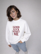 Close-up of female model in white Noiré “Good Luck Without Me” sweatshirt, front view, minimal studio background.