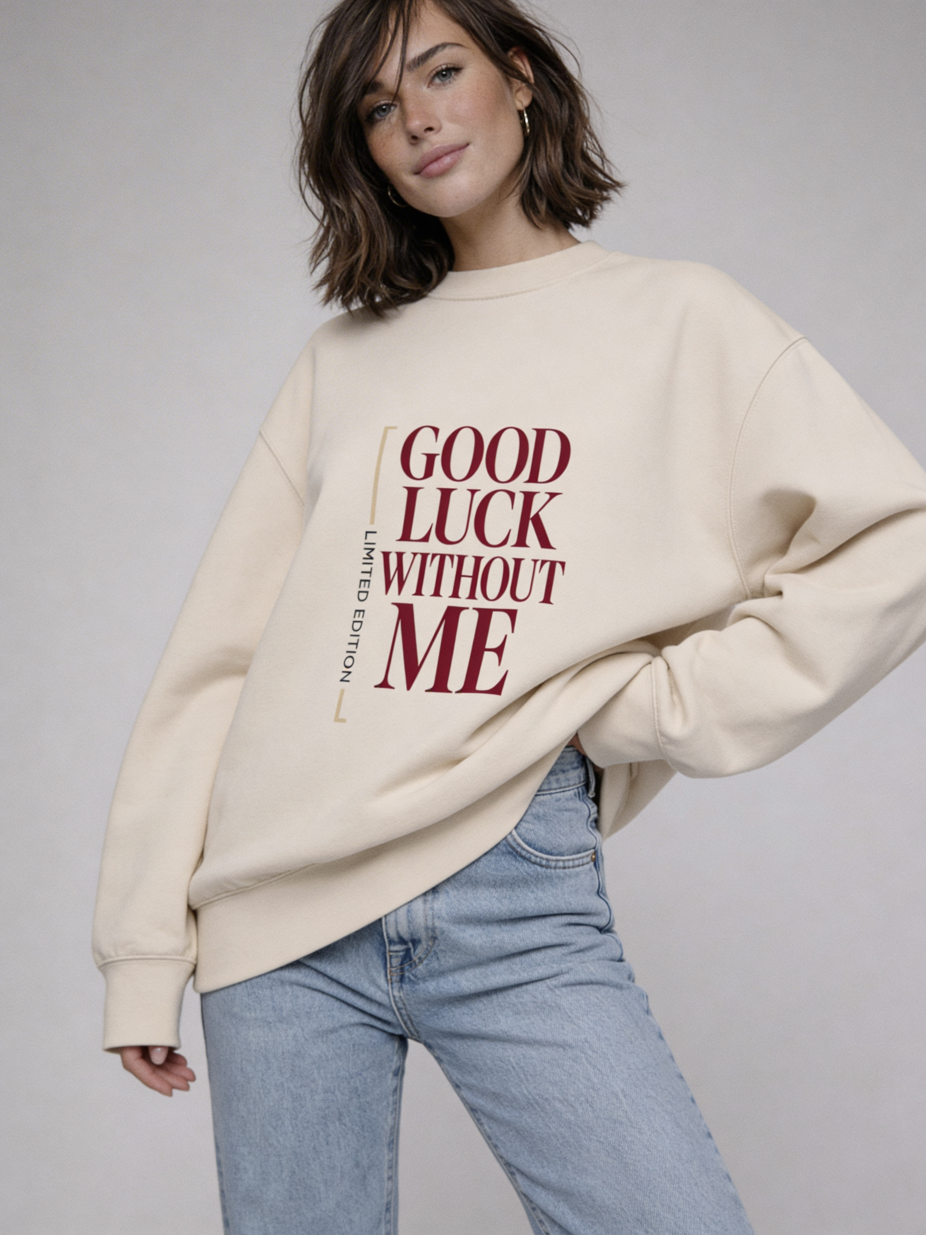 Close-up front view of beige Noiré “Good Luck Without Me” sweatshirt on female model, editorial studio portrait.