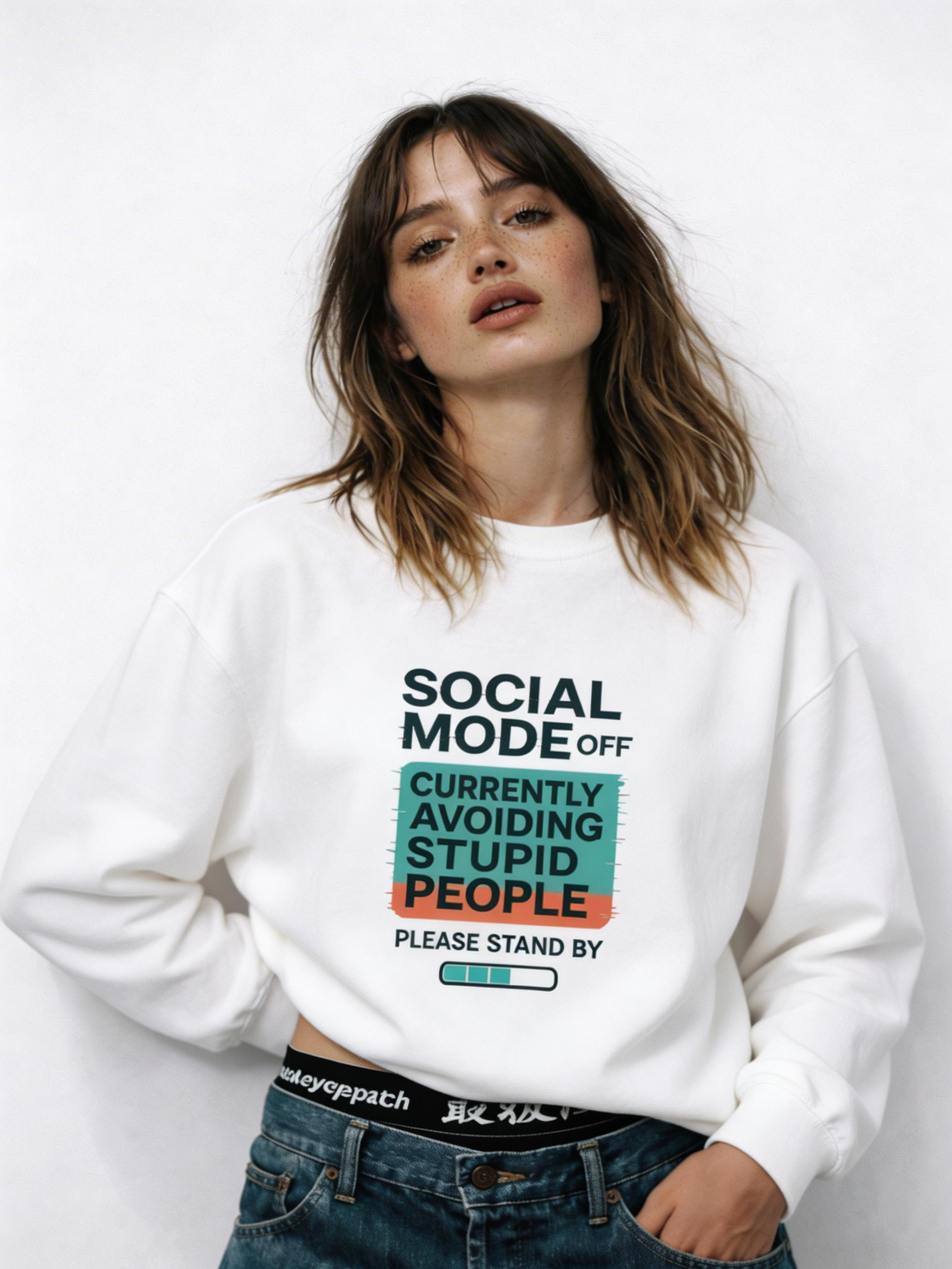 Women’s white oversized sweatshirt with “Social Mode Off – Currently Avoiding Stupid People – Please Stand By” graphic print on the front, casual streetwear outfit styled with blue jeans.