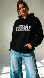 female model relaxed pose wearing oversized black graphic hoodie compare yourself quote design streetwear clothing