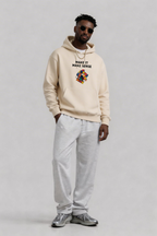 male model relaxed pose wearing sand beige oversized hoodie with colorful graphic print urban streetwear outfit
