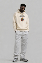 male model looking down wearing oversized beige hoodie with cube graphic print urban streetwear fashion look