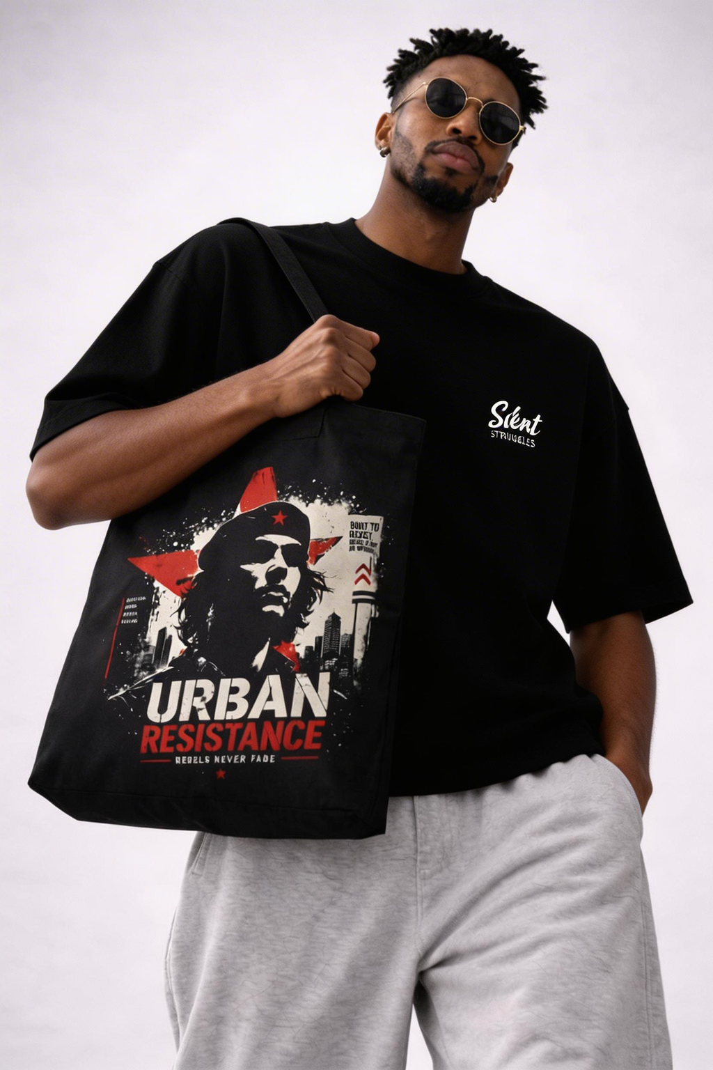 male model close up holding tote bag urban resistance design detail streetwear fashion