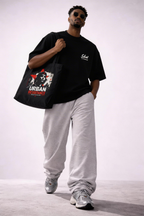 male model walking holding black graphic tote bag urban resistance print casual streetwear style
