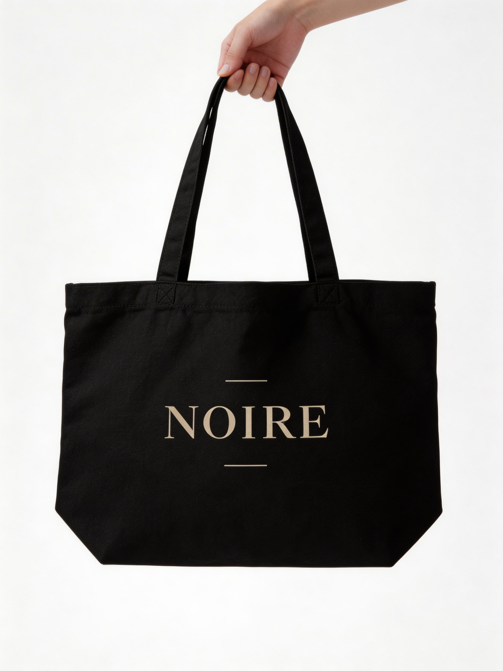 model hand holding black oversized eco tote bag NOIRE logo clean minimal design urban streetwear accessory