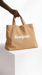 model holding beige tote bag bonjour typography design streetwear fashion