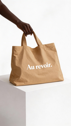 model holding beige tote bag au revoir typography design streetwear fashion