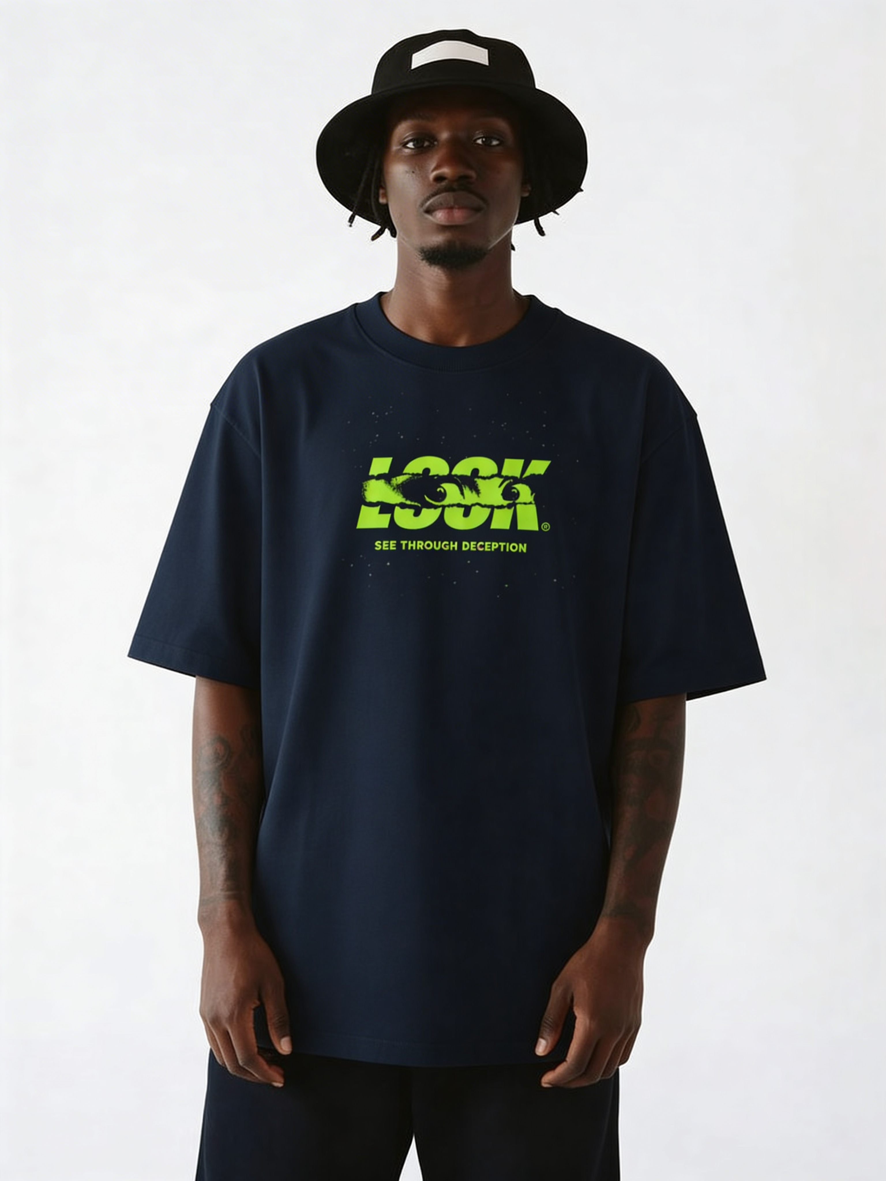 Navy oversized streetwear T-shirt featuring neon green “LOOK – See Through Deception” statement graphic on front, male model styling relaxed fit urban fashion tee.