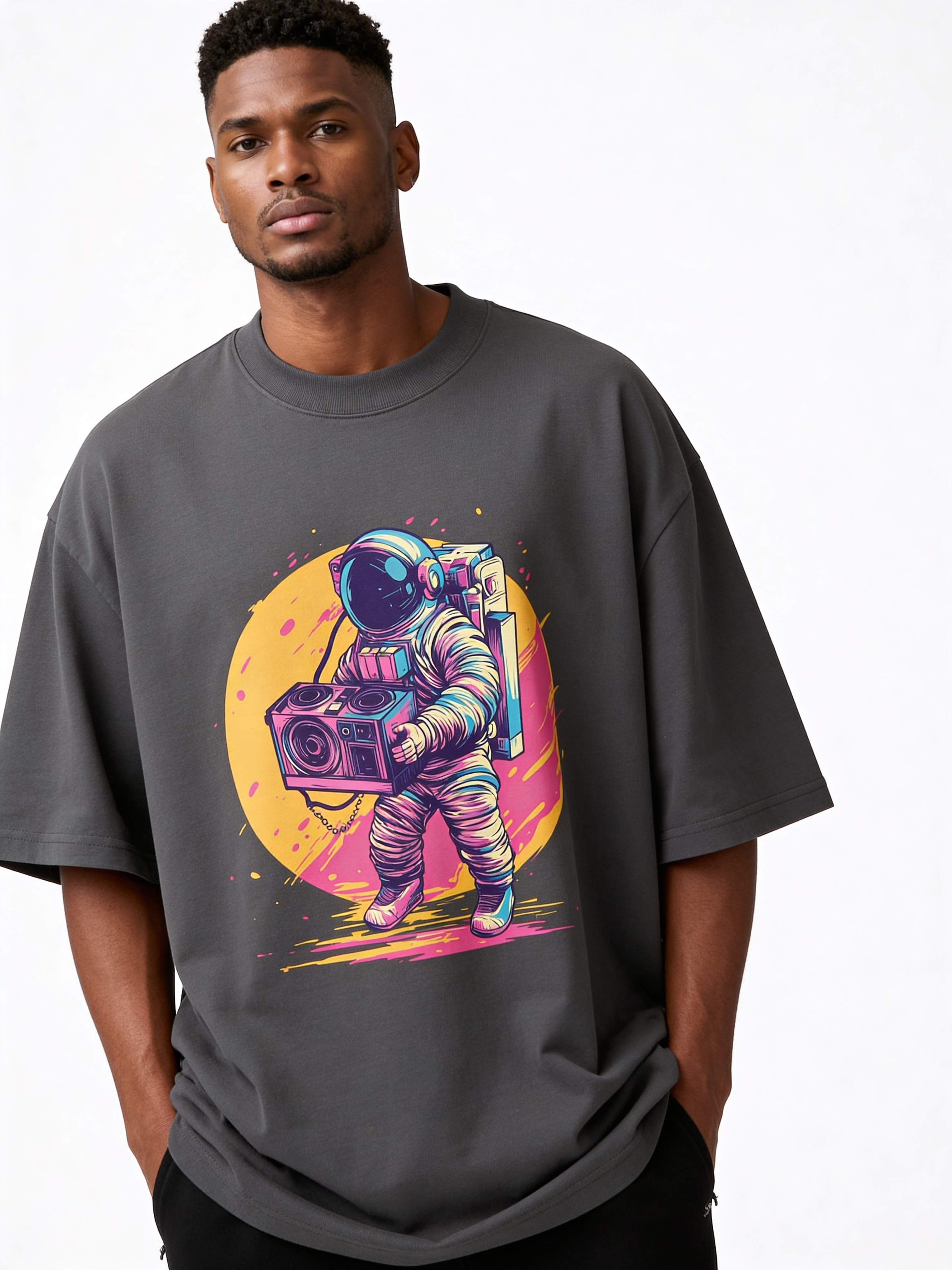 Male model wearing oversized dark grey streetwear t-shirt with colorful astronaut holding boombox graphic print, modern men’s urban fashion studio shot