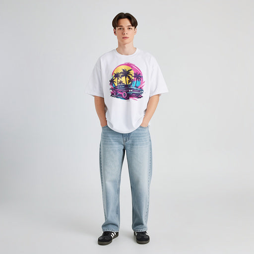 Full body model wearing white unisex graphic t-shirt with colorful sunset palm tree illustration, modern streetwear look