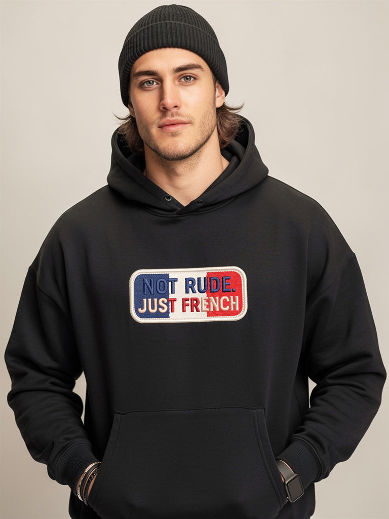 Model wearing black oversized hoodie with “Not Rude Just French” statement patch