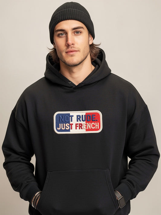 Model wearing black oversized hoodie with “Not Rude Just French” statement patch