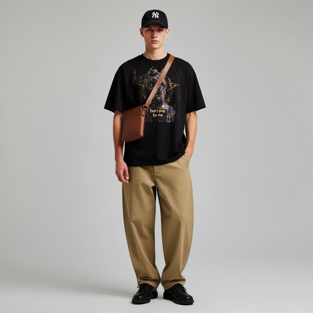 Model wearing a black oversized graphic tee front view with marble statue illustration and gold geometric design