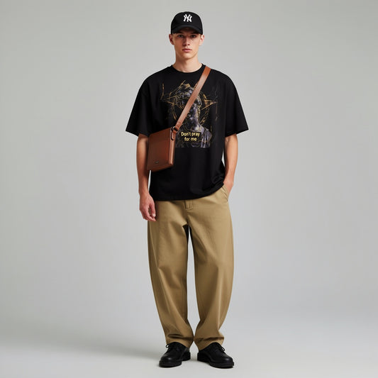 Model wearing a black oversized graphic tee front view with marble statue illustration and gold geometric design