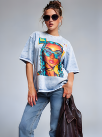 Model wearing unisex denim graphic t-shirt with colorful pop art portrait design in a studio setting