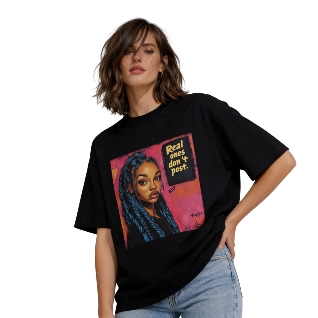 Female model wearing oversized black streetwear T-shirt with “Real ones don’t post” graphic portrait print, paired with light blue jeans.
