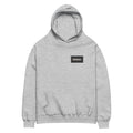 Oversized hoodie in medium grey with "Minimal But Never Basic" statement typography, front view