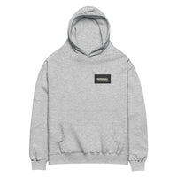 Oversized hoodie in medium grey with "Minimal But Never Basic" statement typography, front view