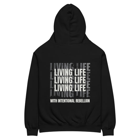 Black oversized hoodie featuring repeated “Living Life” typography and the phrase “Living life with intentional rebellion” printed on the back.
