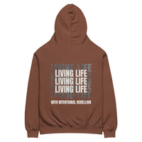 Chestnut oversized hoodie featuring repeated “Living Life” typography and the phrase “Living life with intentional rebellion” printed on the back.